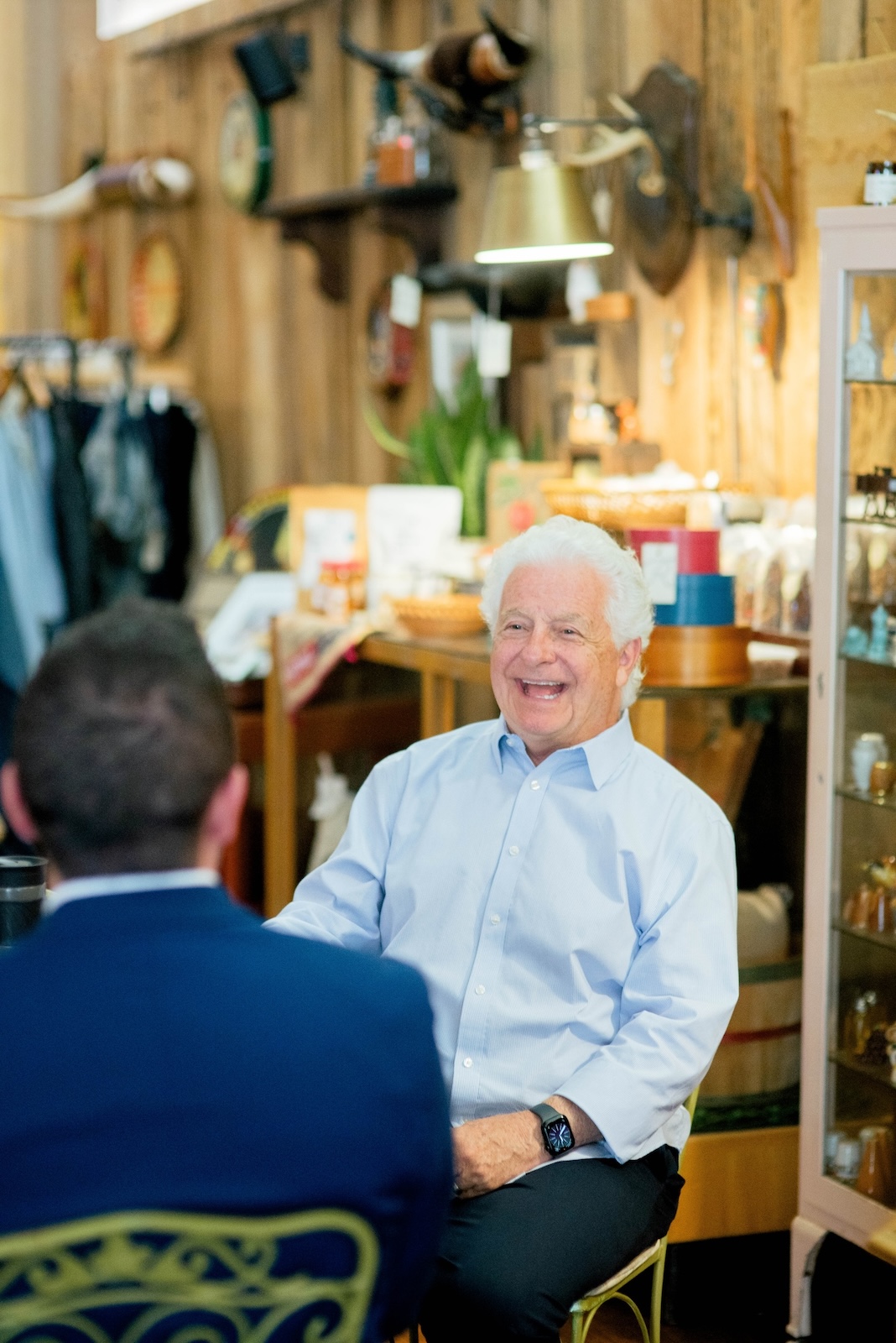 Dr. Dan Francis sitting and talking with a visitor in a local shop